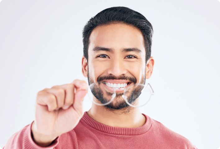 A young man is holding eyeglasses