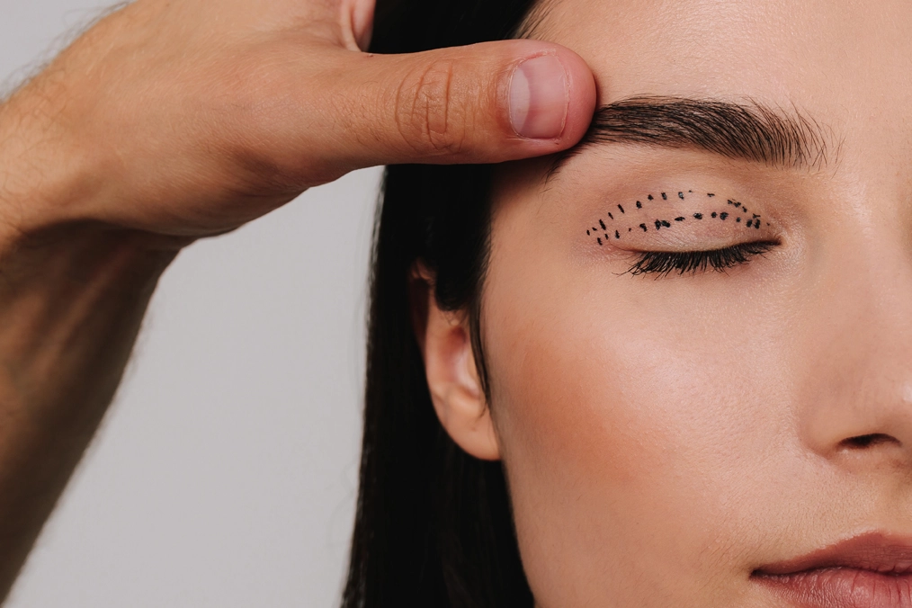 An eye surgeon taking measurements for blepharoplasty